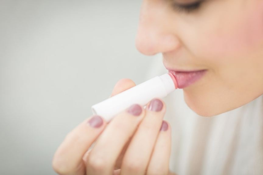 woman applying lip balm to her lips