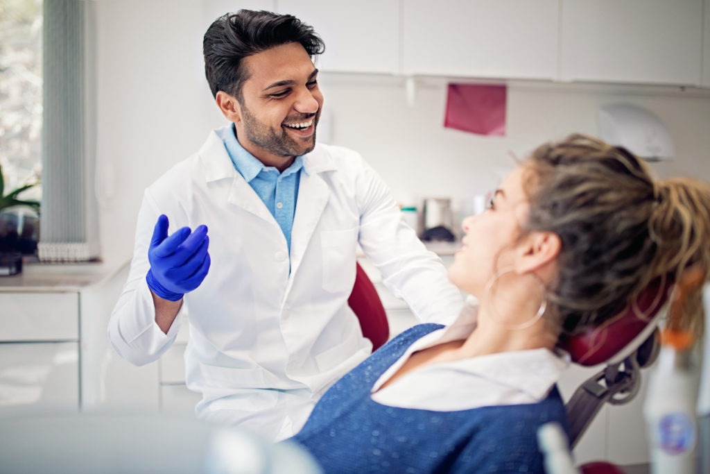 Dentist is working with patient in his office