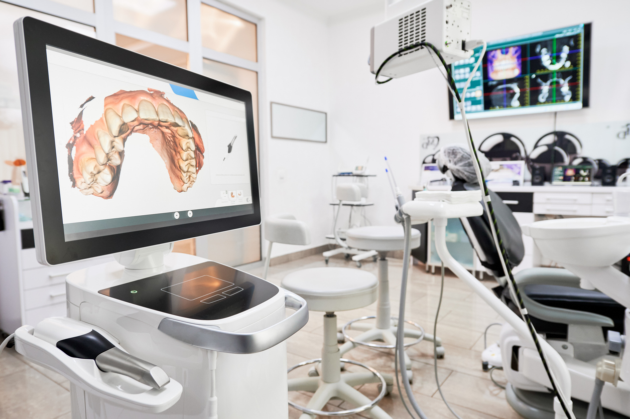 Interior of dental office with modern equipment and dental intraoral scanner with teeth on display