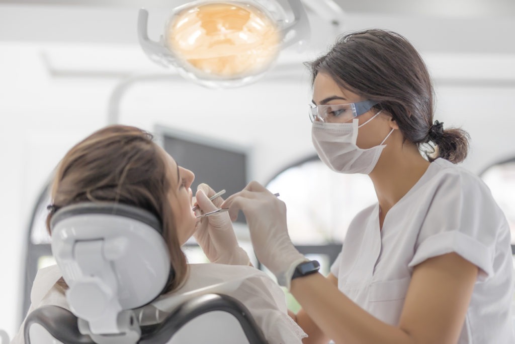 Female Dentist examining her patient in dental clinic