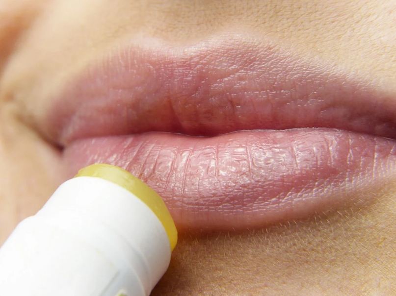 fair skin, pink and moisturized lips, yellow lip balm