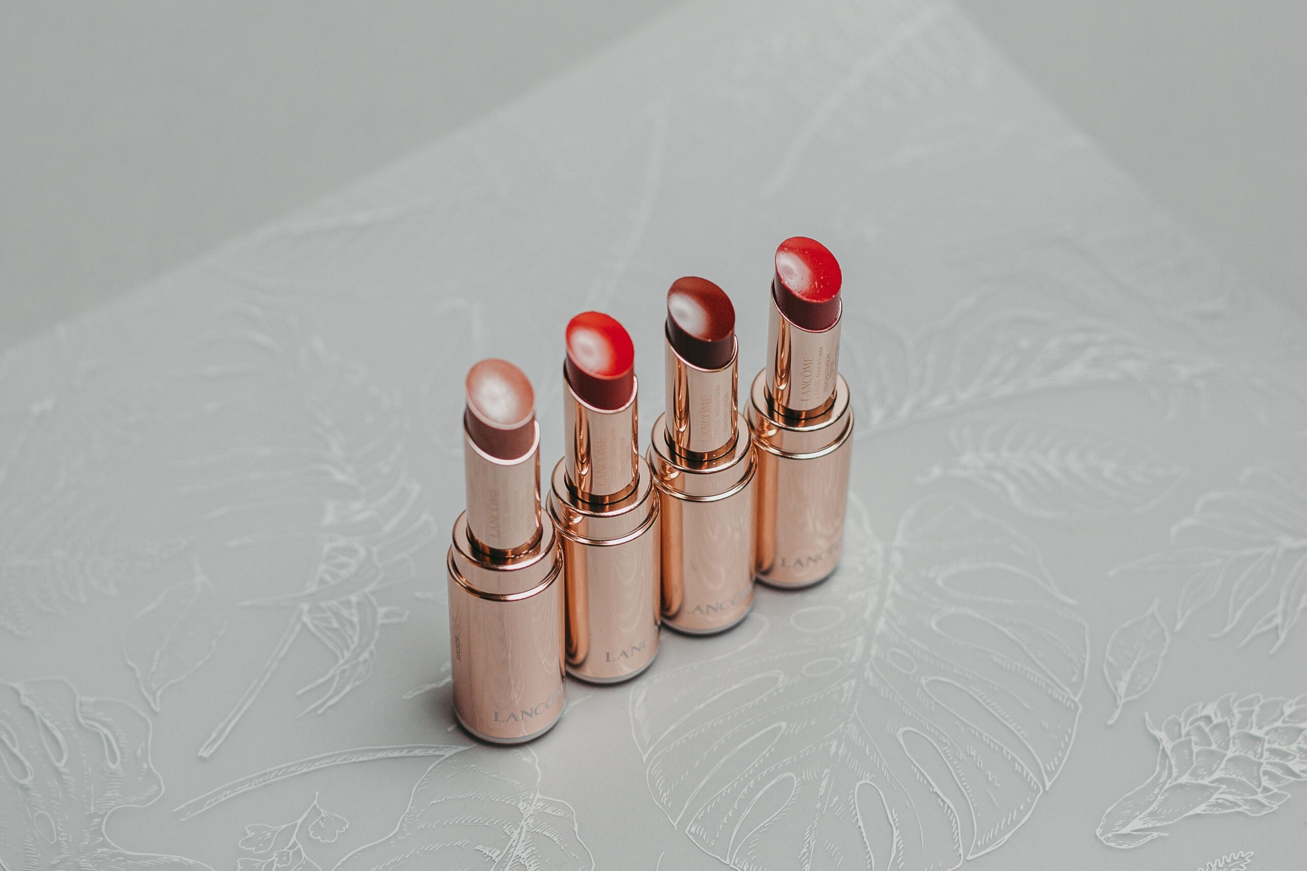 two-brown-and-red-lipstick-on-white-textile