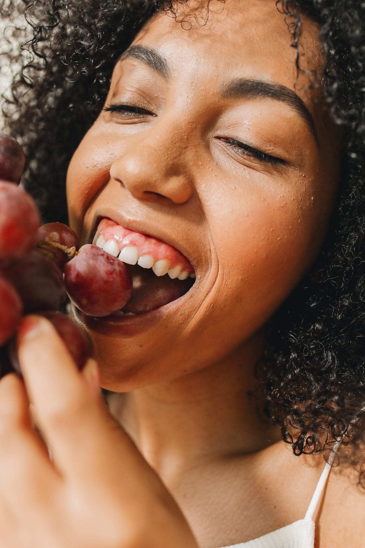 woman eating grapes and smiling