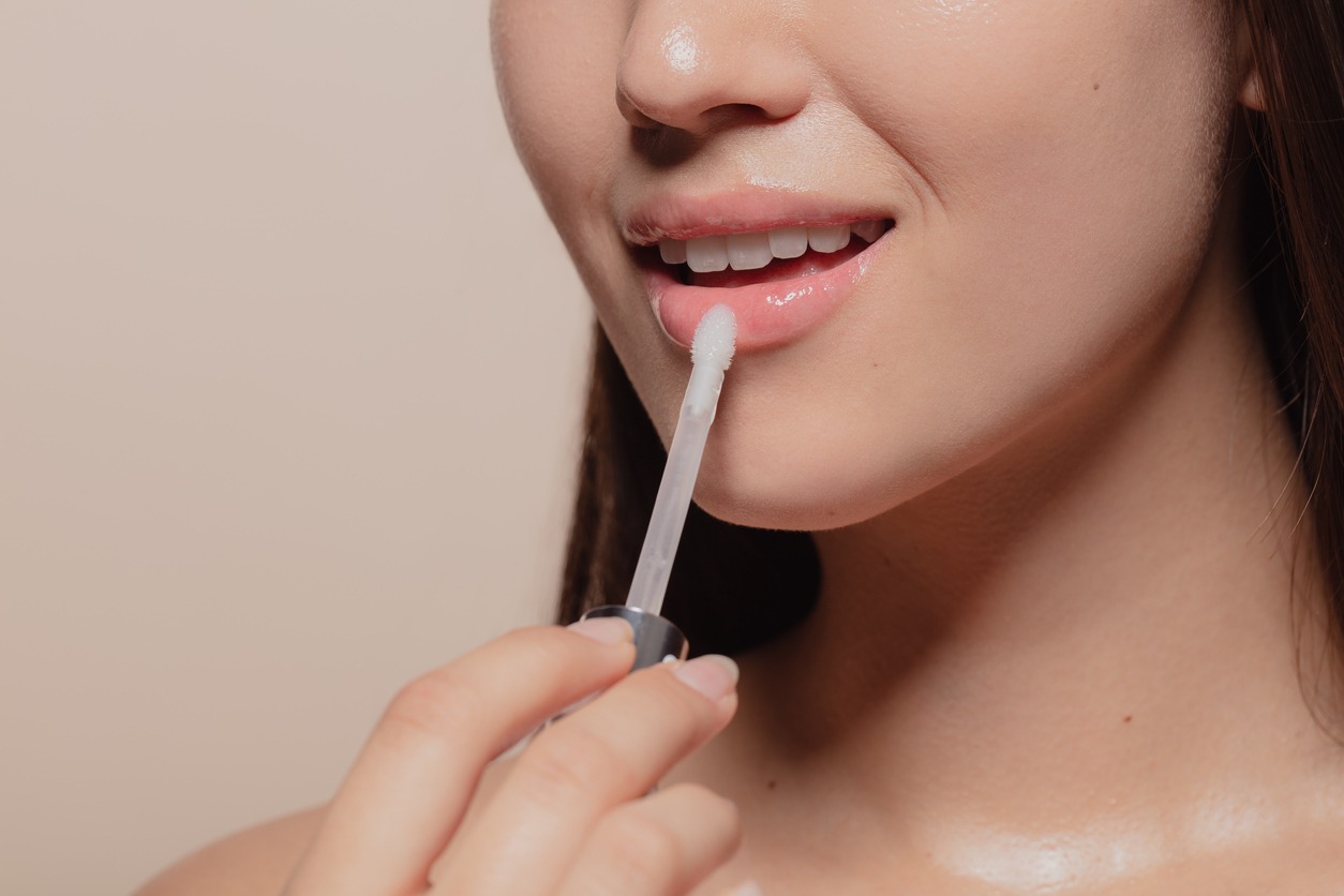 Applying transparent lip gloss lip care